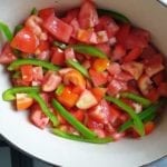 Braadpan met de tomatenstukjes en repen groene paprika