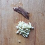 Houten snijplank met knoflook en ansjovis