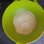 Doe het amandelmeel met het kokosmeel in een kom