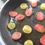 Zodra de olijfolie heet is de tomaatjes in een leuk patroon in de pan leggen