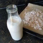 Giet de amandelmelk in een fles en droog de amandelpulp op bakpapier op een oventray