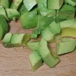 Houten snijplank met stukjes avocado