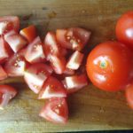 Houten snijplank met stukjes tomaat