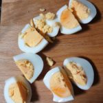 Houten snijplank met in kwarten gesneden hardgekookte eieren