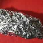 Snijplank met in aluminiumfolie ingepakte varkenshaas