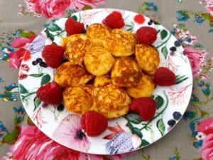 Bord met poffertjes met frambozen