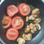 Leg de plakjes tomaat in de pan met champignons