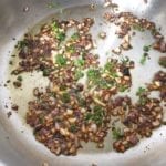 Koekenpan met olijfolie, ui, knoflook en tijmblaadjes