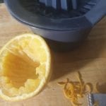 half uitgeperste sinaasappel en wat sinaasappel rasp