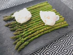 Zwarte schaal met asperges en gepocheerde eieren