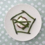 Wit bord met gegrilde asperges, gegrild tartaartje en gepocheerd ei