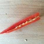 Houten snijplank met chili peper met zaadjes