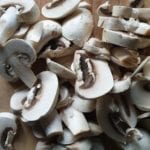 In plakjes gesneden champignons op een snijplank