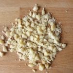 Houten snijplank met grof gehakte macadamia noten