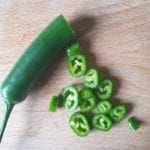 Houten snijplank met in ringetjes gesneden groene chili peper