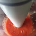 Tomatenblokjes met sap in beker van handblender