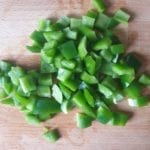 Snijplank met stukjes groene paprika