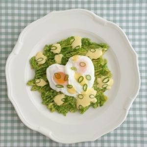 Wit bord met gepocheerde eieren op avocado met citroenmayonaise