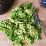 Snijplank met fijngeprakte avocado